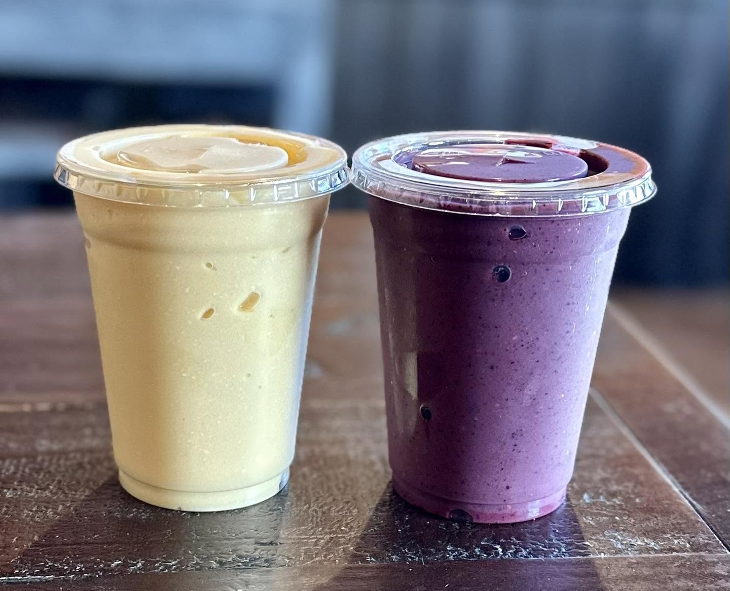 Two fresh-blended smoothies, mango and mixed berry
